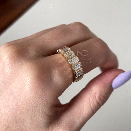 Close up of emerald cut moissanite eternity ring, bezel set in Yellow gold, showcasing brilliant diamond sparkle in a sleek and minimalist wedding band for women, 14k Yellow gold, Diamond Simulant band, Eternity Ring, Diamond Ring, Emerald Moissanite, Emerald Cut Diamond Wedding Band, Emerald Diamond Bezel Set, Eternity Moissanite Diamond Ring, Promise Ring, Anniversary Ring, Emerald Cut Lab Diamond Half Eternity Band, Wedding Ring, Modern Moissanite Stacking Band, Minimalist Bridal Ring