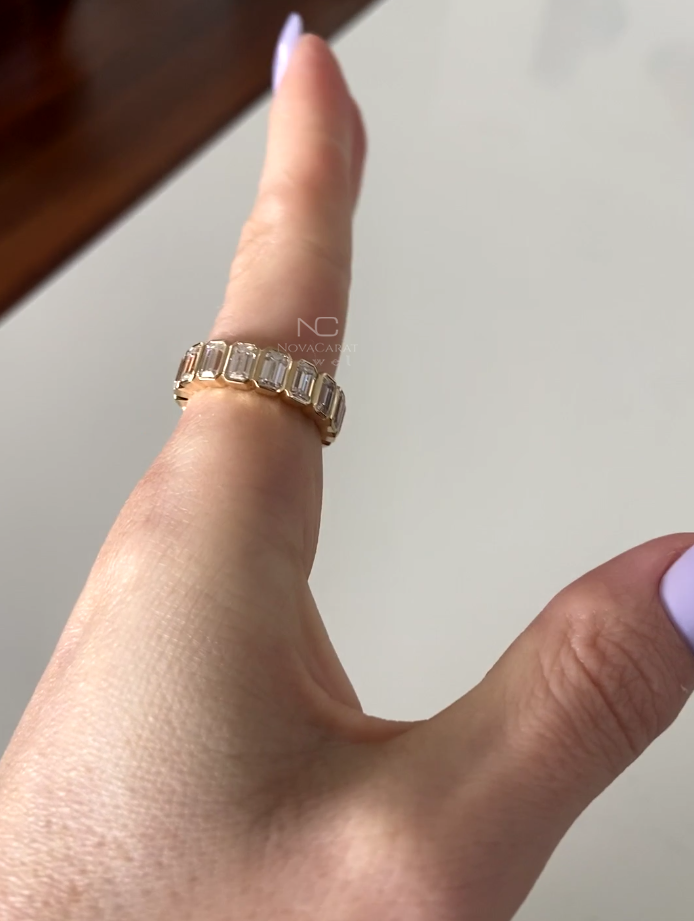 Front view of emerald cut moissanite eternity ring, bezel set in 14k Yellow gold with brilliant diamond sparkle, elegant minimalist wedding band gift for anniversaries and special occasions. Emerald cut moissanite eternity band in 14k gold. Bezel set minimalist stacking ring, perfect bridal wedding band, promise or anniversary gift. wedding band, promise or anniversary gift, Emerald Cut Bezel Set Moissanite Diamond Wedding Band, 14K Yellow Gold Dainty Anniversary Gift For Ring, Bridal Set Ring